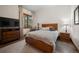 Comfortable bedroom with wood flooring, bed and nightstands, view of a forest, and flat screen television at 6016 Stone Creek Dr, Evergreen, CO 80439