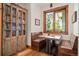 Cozy dining nook with built-in seating, a wooden table, and a charming window view at 6016 Stone Creek Dr, Evergreen, CO 80439