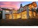 Exterior view of luxury home with a large backyard, elevated deck, and outdoor seating at sunset at 6016 Stone Creek Dr, Evergreen, CO 80439