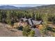 Expansive home with stone and wood accents, surrounded by lush trees and mountain views at 6016 Stone Creek Dr, Evergreen, CO 80439