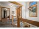 Foyer featuring wood railing, cage light fixture, and natural light at 6016 Stone Creek Dr, Evergreen, CO 80439