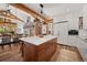 Spacious open-concept kitchen with a large island, wood floors, and view into the dining area at 6016 Stone Creek Dr, Evergreen, CO 80439
