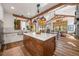 Bright, open kitchen with wooden beams, an island, and views into the dining and living areas at 6016 Stone Creek Dr, Evergreen, CO 80439