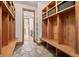 Mudroom featuring wood storage lockers, built-in benches, and stone flooring at 6016 Stone Creek Dr, Evergreen, CO 80439