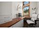 Office featuring custom wood desk, built-in drawers and shelving, and a large window at 6016 Stone Creek Dr, Evergreen, CO 80439
