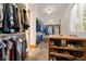 Organized walk-in closet featuring custom shelving, hanging racks, and stone floors at 6016 Stone Creek Dr, Evergreen, CO 80439