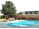 Community pool surrounded by lounge chairs and mature trees at 2225 Buchtel Blvd # 202, Denver, CO 80210
