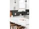 Close up of a modern kitchen island with stools, quartz countertops, and stylish pendant lighting at 3955 W 13Th Ave, Denver, CO 80204
