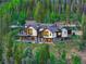 Luxury home featuring an outdoor hot tub, fire pit, and views of surrounding forest at 2300 Boreas Pass Rd, Breckenridge, CO 80424
