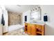 Bright bathroom featuring a shower, bath, vanity, and storage, with warm brown tones at 10181 E 112Th Way, Commerce City, CO 80640