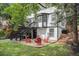 Spacious backyard with mature trees, patio, gravel area, and steps to upper level at 11022 Trailrider Pass, Littleton, CO 80127