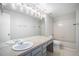 Bathroom features a shower and tub combo, large mirror, and neutral countertops at 11022 Trailrider Pass, Littleton, CO 80127