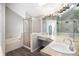 Bright bathroom features a shower, soaking tub, tile and plank flooring, and ample vanity space at 11022 Trailrider Pass, Littleton, CO 80127