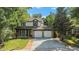 Charming two-story home boasts mature trees, lush landscaping, and two-car garage at 11022 Trailrider Pass, Littleton, CO 80127