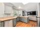 Open kitchen area with tile counters, hardwood floors, stainless steel appliances and open access to living room at 11022 Trailrider Pass, Littleton, CO 80127