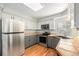 Charming kitchen with stainless steel appliances, tile counters, hardwood floors and white and gray cabinets at 11022 Trailrider Pass, Littleton, CO 80127