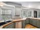 Traditional kitchen features light gray cabinets, tile countertops, stainless steel dishwasher, and hardwood floors at 11022 Trailrider Pass, Littleton, CO 80127
