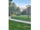 Scenic winding pathway with lush green lawns, mature trees, and vintage street lights at 11022 Trailrider Pass, Littleton, CO 80127