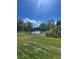 Scenic view of a pond surrounded by lush green grass and mature trees under a clear blue sky at 11022 Trailrider Pass, Littleton, CO 80127