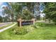 Landscaped entrance sign for The Ranch House with greenery and trees at 11022 Trailrider Pass, Littleton, CO 80127