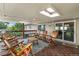 Inviting back deck with string lights, skylights, wood flooring, table, and six rocking chairs at 1261 Eagle St, Aurora, CO 80011