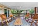 Cozy back deck with string lights, wood floor, wood railings, a wood table and six wood rocking chairs at 1261 Eagle St, Aurora, CO 80011