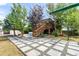 Backyard featuring wood deck, concrete block sidewalk, trees and green lawn at 1261 Eagle St, Aurora, CO 80011
