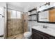 Clean bathroom featuring tiled walk-in shower, modern vanity and open shelving at 1261 Eagle St, Aurora, CO 80011
