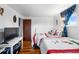 Bright bedroom with two twin beds, a desk, and a window with charming blue curtains at 1261 Eagle St, Aurora, CO 80011