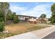 Charming home featuring a well-manicured lawn and a combination brick and siding exterior at 1261 Eagle St, Aurora, CO 80011