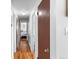 Hallway with wood floors, white walls, and brown doors leading to various rooms at 1261 Eagle St, Aurora, CO 80011