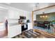 Modern kitchen featuring open-concept access to dining area, white cabinetry and stainless steel appliances at 1261 Eagle St, Aurora, CO 80011