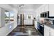 Bright kitchen featuring stainless steel appliances, white cabinetry and dark modern flooring at 1261 Eagle St, Aurora, CO 80011
