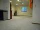 Unfinished basement features carpet flooring, neutral-colored walls, and a window providing natural light at 21734 Farmingdale Ct, Parker, CO 80138