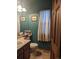 Charming half bathroom with dark green walls, framed artwork, and a wood-trimmed door at 21734 Farmingdale Ct, Parker, CO 80138