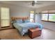Comfortable bedroom featuring a blue patterned bedspread, natural wood headboard, and three bright windows at 21734 Farmingdale Ct, Parker, CO 80138