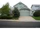 Charming home featuring light-green siding, an attached two-car garage, and a well-maintained front lawn at 21734 Farmingdale Ct, Parker, CO 80138