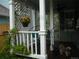 A cozy front porch with white pillars, lattice details, and a hanging flower basket at 21734 Farmingdale Ct, Parker, CO 80138