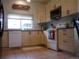 Well-lit kitchen with modern wood cabinets, white appliances, black countertops, and tile flooring at 21734 Farmingdale Ct, Parker, CO 80138