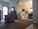 Inviting living area flows into the kitchen, featuring a comfortable armchair and neutral tones at 21734 Farmingdale Ct, Parker, CO 80138