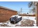 Brick patio and fenced backyard with winter snow at 7505 Robinson Way, Arvada, CO 80003