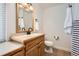 Bathroom with wood vanity, white toilet, and neutral color palette at 7505 Robinson Way, Arvada, CO 80003