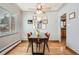 Bright dining room with wood floors, a wooden table, and gallery wall at 7505 Robinson Way, Arvada, CO 80003