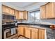 Kitchen with wood cabinets, stainless steel appliances, and corner sink at 7505 Robinson Way, Arvada, CO 80003