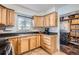 Kitchen with wood cabinets, stainless steel appliances, and laundry area at 7505 Robinson Way, Arvada, CO 80003