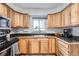 Kitchen boasts wood cabinets, stainless steel appliances, and corner sink at 7505 Robinson Way, Arvada, CO 80003