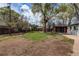 Spacious backyard with a combination of grass, dirt, mature trees and wooden privacy fence at 6220 W 11Th Pl, Lakewood, CO 80214