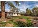 The backyard has grass, dirt, a covered area, trees, and an outdoor patio with seating at 6220 W 11Th Pl, Lakewood, CO 80214
