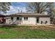 White brick home featuring a spacious backyard with green grass and mature trees at 6220 W 11Th Pl, Lakewood, CO 80214