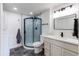 Remodeled bathroom with a walk-in shower featuring glass doors and modern fixtures, including a modern vanity at 6220 W 11Th Pl, Lakewood, CO 80214